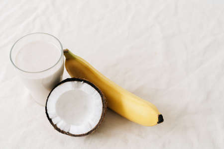 white healthy smoothie made of banana and fresh coconut, in a glass glass. healthy breakfast, healthy lifestyleの写真素材