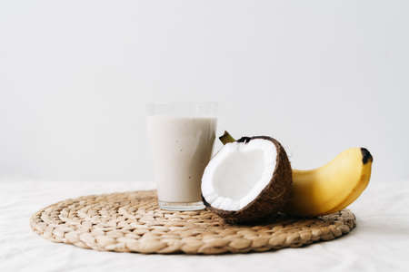 white healthy smoothie made of banana and fresh coconut, in a glass glass. healthy breakfast, healthy lifestyleの写真素材