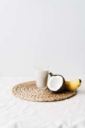 white healthy smoothie made of banana and fresh coconut, in a glass glass. healthy breakfast, healthy lifestyleの写真素材