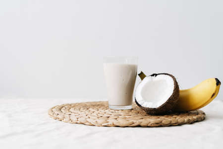 white healthy smoothie made of banana and fresh coconut, in a glass glass. healthy breakfast, healthy lifestyleの写真素材