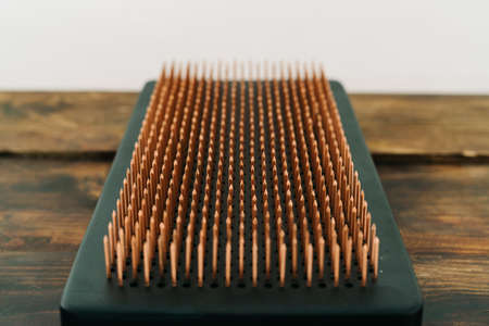 a sadhu board made of dark oak with copper nails on a wooden floor. the yogic practice of standing on nailsの写真素材