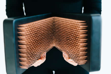 a sadhu board made of dark oak with copper nails on a wooden floor. the yogic practice of standing on nails. high quality photoの素材 [FY310184613984]