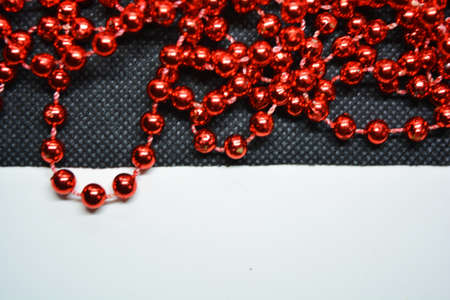 New Year and Christmas red beads for the New Year tree are randomly scattered on white and black fabric backgrounds.の写真素材