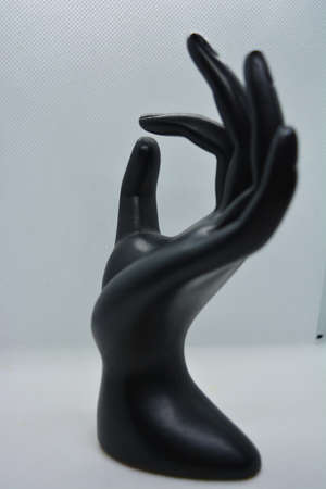 Black elegant stone, faience woman's hand, brush, palm with a slight glow of light is located on a...