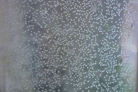 Small, round, spherical bubbles covered the surface of a plastic container of water. Mysterious and...