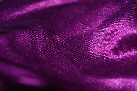Bright colorful, rich velvet purple background with overflow and ebb. An unusual shaggy purple fabric with curves and waves is located on a flat surface, an unusual look.の写真素材