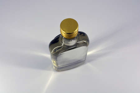 Classic glass bottle of 500 ml with swelling neck and gilded lid for alcoholic and strong drinks located on a white background.の写真素材