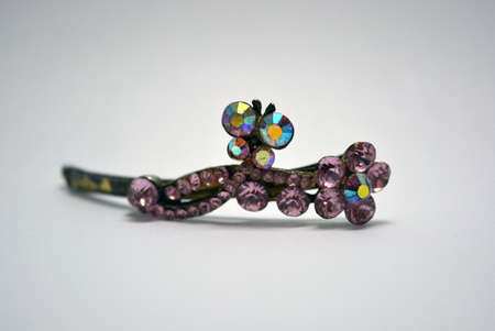 Metal female hair clip decorated with large pink beautiful stones and located on a white background.の写真素材
