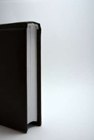 A small book, a notebook, a diary in a dark brown cover is located on a white background with interesting lighting.の写真素材