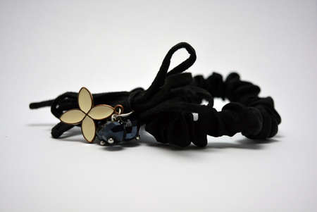 Women's fabric black hair tie, hair ornament with white metallic flower and black stones.の写真素材
