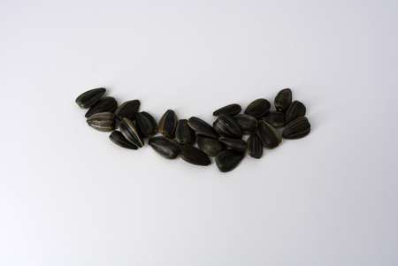 Delicious fried black sunflower seeds fastened into plastic containers and interesting lighting.の写真素材