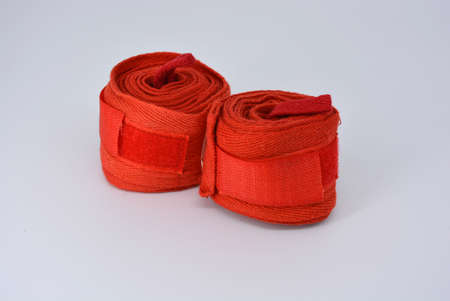 Sports equipment for martial arts, mixed struggle, boxing. Red raised rolls of thick bandages, sporty ribbons for hands. Fissure cotton material to protect hands.の写真素材
