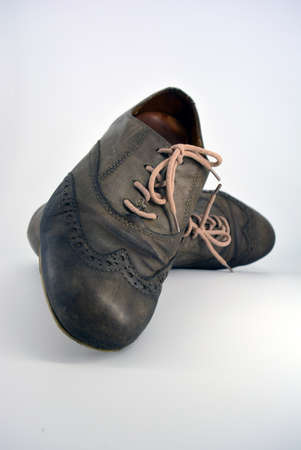 Female leather shoes located on a white background. Oxford shoes with gray shoelaces on a flat heel....