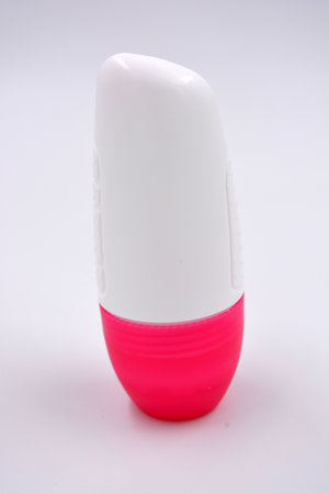An interesting plastic packaging from women's roll-on deodorant with a pink plastic lid is located on a white background.の写真素材