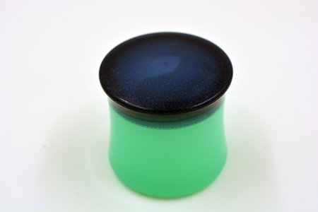 Cosmetics, face cream, face and body skin care in a green plastic stylish jar with a blue lid is located on a white background.の写真素材