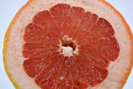 Fresh fruit, delicious and healthy yellow red ripe grapefruit lies cut with a red core on a white background. Grapefruit cut in half on a white background close-upの写真素材