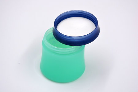 Cosmetics, face cream, face and body skin care in a green plastic stylish jar with a blue lid is located on a white background.の写真素材