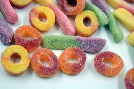 Sweets of children's candies in the form of sweet earthworms of different colors, American donuts,...