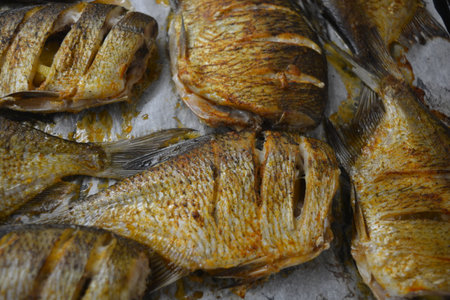 Fried fish on a baking sheet, close-up. Seafood. Delicious and healthy, baked fish, Carassius with...