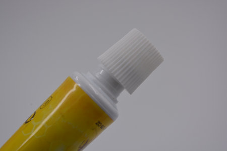 Close-up of a tube of yellow paint on a white background. Medicine, medicines, dental and oral care...