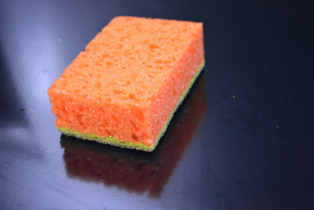 Sponge for washing dishes on a black background, closeup of photo. Colored washcloths for washing...