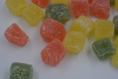 Jelly candies isolated on white background. Selective focus. Beautiful, small pieces of gummy confections. Delicious, natural, fruity marmalade in green, yellow, red.の写真素材