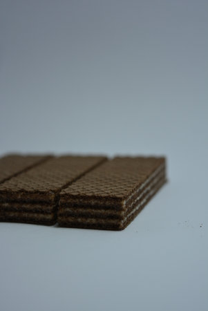 Close up of chocolate wafers isolated on a white background. On white paper sweet chocolate wafers with white coconut filling.の写真素材