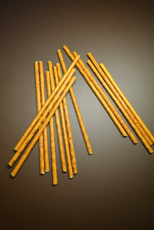 Biscuit sticks on a gray background. Selective focus. Food, fresh sweet straws on a brown matte...