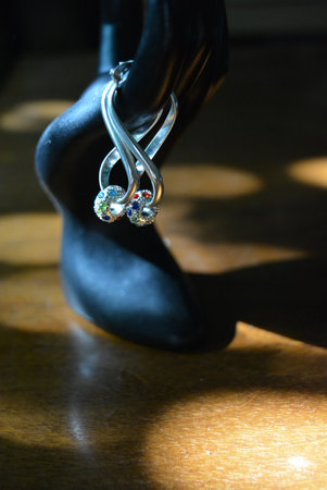 Womens black high-heeled shoes with a ring. Black statuette of a matte female hand with silver earrings with beautiful stones and a pendant.の写真素材