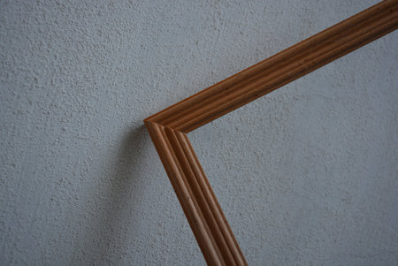 Beautiful wooden picture frame of light wood on a white building wall background