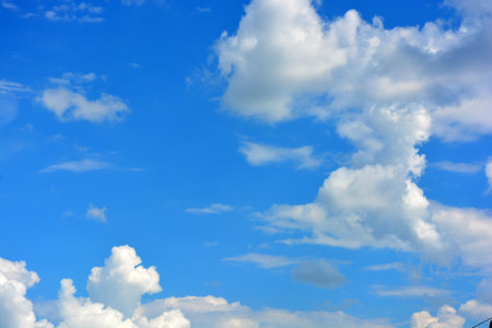 Blue sky background with tiny cloudsuse as background or wallpaper. Beautiful nature, bright and colorful weather. Large bright white, fluffy clouds against beautiful blue sky.の写真素材