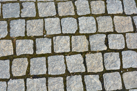 Cobblestone pavement background. Close up of cobblestone pavement texture. Beautiful stones, gray cobblestones, gray stones laid out textured on the ground, masonry with stones.の写真素材
