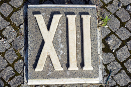 Alphabetic plate with the name of the city. White inscriptions in gray granite of Roman numerals.の写真素材