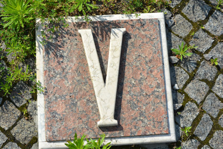 Stone letter V on background of the stone pavement in the park. White inscriptions in gray granite of Roman numerals one, two, three, four, five, six, seven, eight, nine and ten.の写真素材