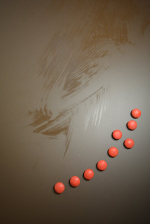 Red pills on a black background. Copy space. Toned. Beautiful bright small colored round candies...
