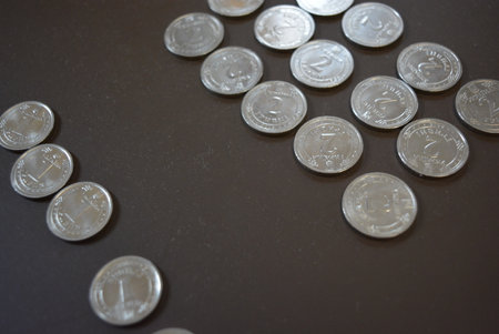 Thai Baht coins on black background. (Thai Baht). White metal Ukrainian coins, silver kopecks are...