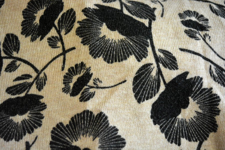 The texture of the fabric is black with a pattern of flowers.  Beige fabric, finely weaved, dyed...