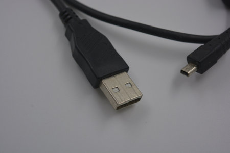 USB cable isolated on a white background. Close up. Selective focus. Black rubber, plastic usb cable...
