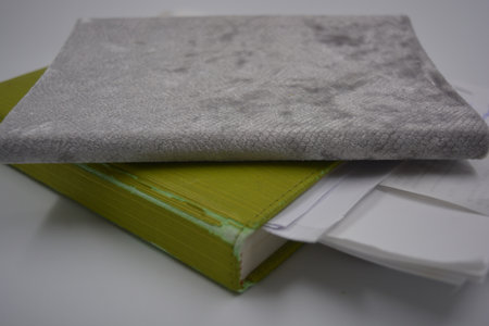 A stack of books on a white background, close-up. Beautiful books, a notebook in a bright green,...