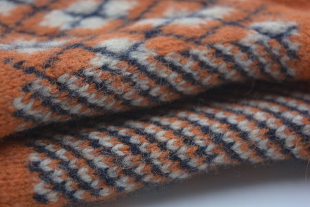 Knitted woolen fabric as a background, closeup of photo. Warm, soft, winter knitted fabric made of...