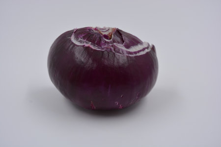 Purple onion on a white background. Close up. Studio shot. Healthy, wholesome food, fruits and vegetables. Half of a whole purple onion is located on a white matte background.の写真素材