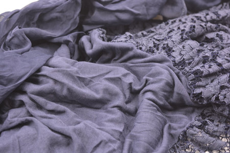 This is a photograph of a piece of fabric, material or texture. Unusual fabrics, crumpled thin dark blue cotton, viscose with lace with flowers.の写真素材