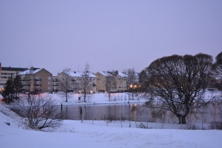 Winter landscape with river, houses and trees in the snow, nature series. A colorful landscape on the shore of central part of Varkaus city, Finland.の写真素材