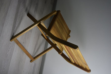 Wooden chair in the interior of the room with light and shadow. Unusual wooden background made of wooden railings, thin docks with beautiful wooden reflection, lighting.の写真素材