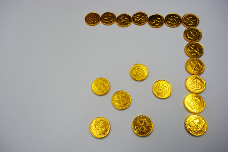 Number five made of gold coins on a white background with space for text. Beautiful, large gold coins, cents with a dollar $ sign are located on a white plastic background.の写真素材