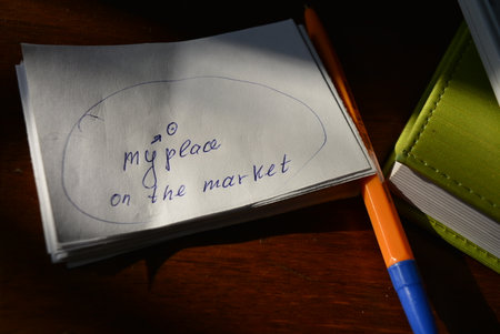 Notebook and pen on wooden table. Motivational quote. Small white pieces of paper with blue ink lettering are arranged on a brown wooden background.の写真素材