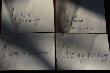 Two pieces of paper with the inscriptions are arranged on a brown wooden background.の写真素材