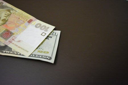 Money on a black background. American dollars and euro banknotes. Things and objects that are used every day are twenty dollars and one hundred hryvnias.の写真素材