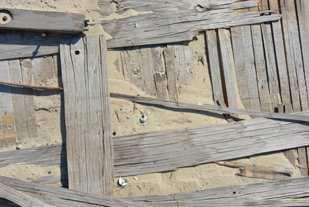 Wooden bridge on the beach, close-up of photo. Things burnt wood, old broken sleepers from the...