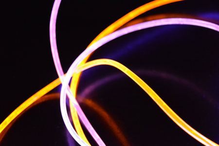 Abstract light painting on the black background. Colorful abstract. Beautiful and unusual graphic. Multicolored light, beams of light pass along plastic twisted tubes.の写真素材